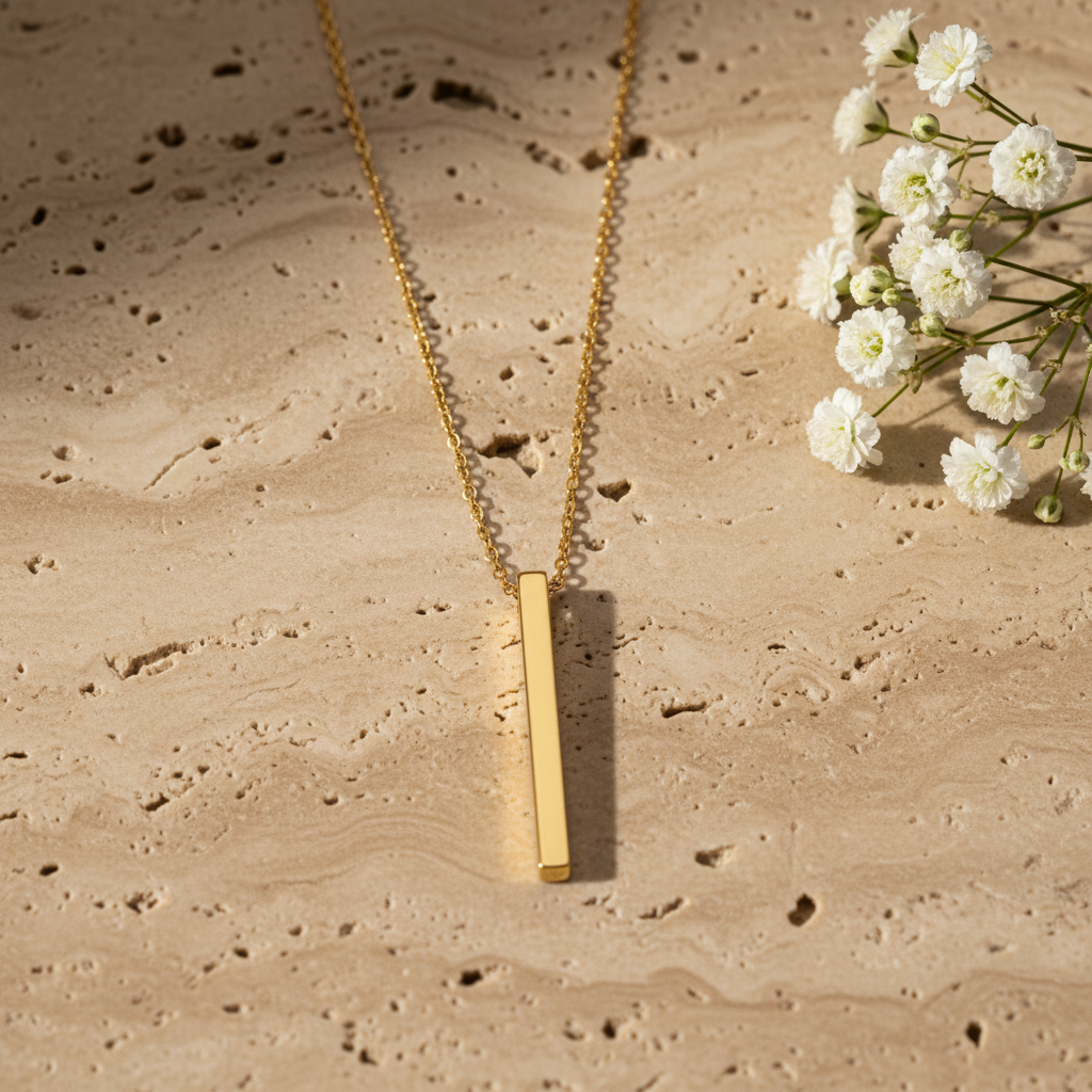 Radiance drop necklace on warm stone with flowers