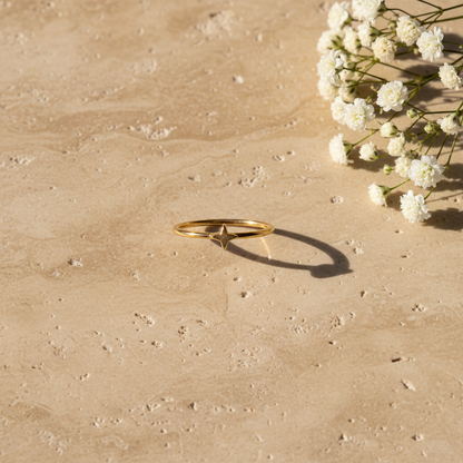 Celestial star midi ring on warm stone surface with flowers